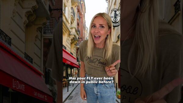 A person in casual attire smiles in a narrow street with Parisian-style buildings and a red awning labeled "Le Dante." Text overlay present.