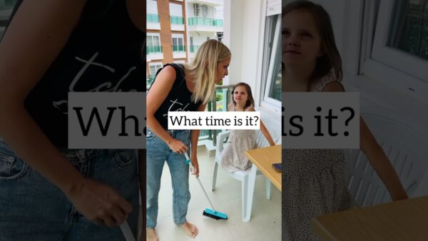 A person with a broom talks to a seated child on a balcony. Text asks, "What time is it?" Nearby buildings visible.