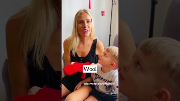 A person and child indoors, holding red wool. The child looks up at the person, with "Wool" text overlayed.