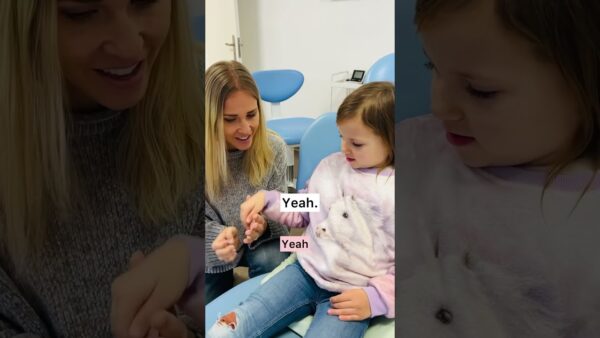 A person and child sit together in a room. The child wears a sweater with a horse print. "Yeah" text overlays the image.